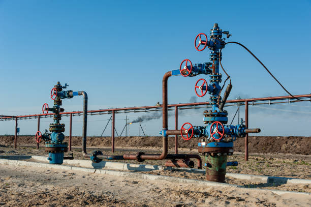 Petroleum well wellhead equipment. Hand valve with handwheel on the flow line. Oilfield site. Oil, gas industry concept. Industrial site background. Production oil. Multiple check valve gate armature. Petroleum well wellhead equipment. Hand valve with handwheel on the flow line. Oilfield site. Industrial site background. Production oil. Multiple check valve gate armature. Oil, gas industry concept. oil wellhead stock pictures, royalty-free photos & images