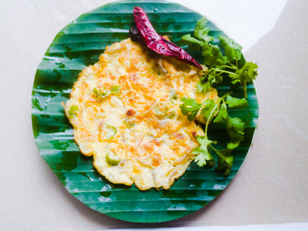 istock Egg Omelette with coriander leaves and red chillies in a banana leaf. 1264682409