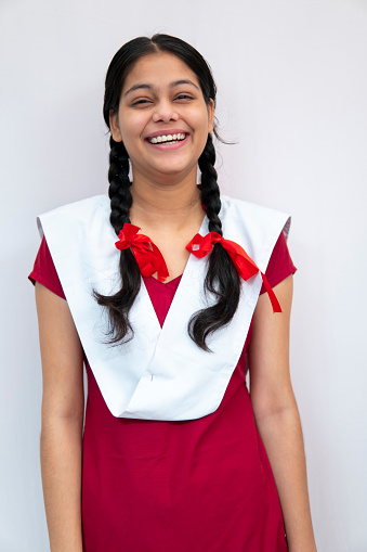 Happy Indian Girl In School Uniform With Braided Hair Standing Against  White Background Stock Photo - Download Image Now - iStock