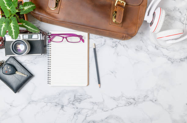 istock Blank  notebook woth vintage Leather bag and  vintage camera on marble table 1264685190