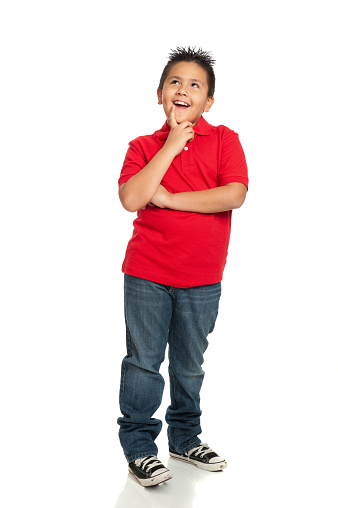 Nine year old Mexican boy standing up against white background