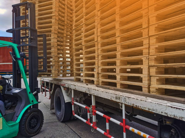 istock Worker driving forklift to loading and unloading wooden pallets from truck to warehouse cargo storage, shipment in logistics and transportation industrial, wood pallets stack 1264691648