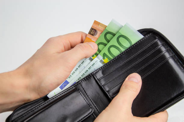istock Man's hand pulling euro cash from the wallet isolated 1264695228