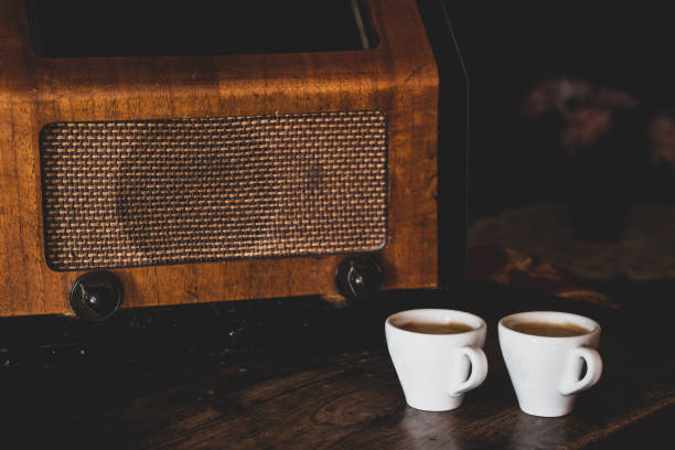 deux tasses de café avec expresso et radio rétro sur fond en bois foncé. tonalité de couleur vintage - fresh coffee audio photos et images de collection