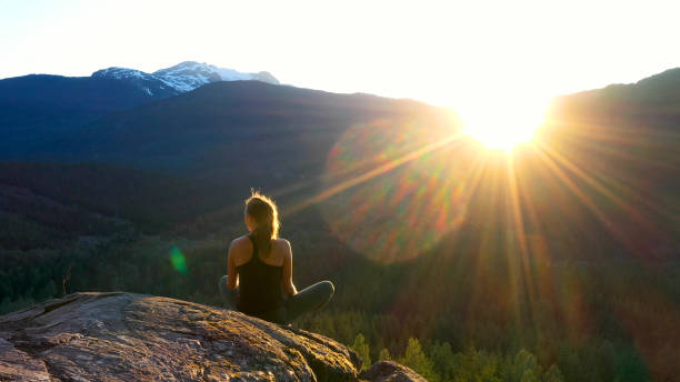 istock Young woman performs yoga moves on rock slabs 1264697769