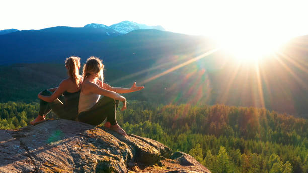 istock Young women relax on rock slabs, look off to view 1264697779