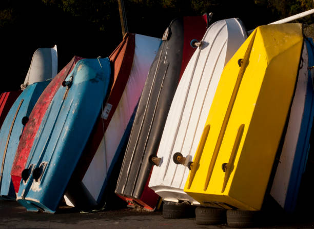 istock Small multicolored fishing boats leaning upside down on dock at dusk. 1264698659