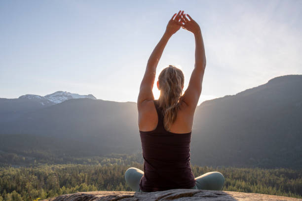 istock Young woman performs yoga moves on rock slabs 1264698685