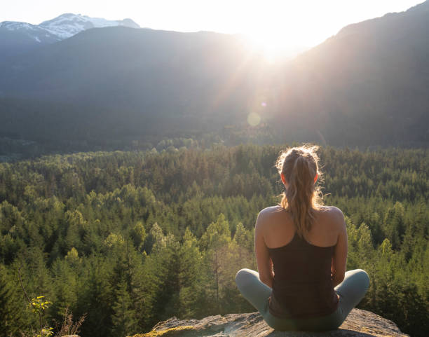 istock Young woman performs yoga moves on rock slabs 1264698723