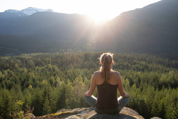 istock Young woman performs yoga moves on rock slabs 1264698726
