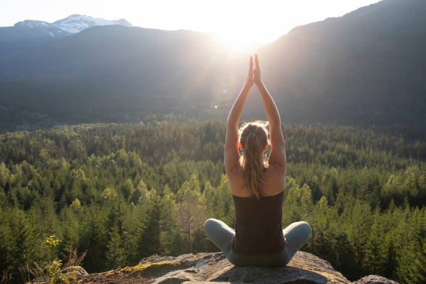 istock Young woman performs yoga moves on rock slabs 1264698845