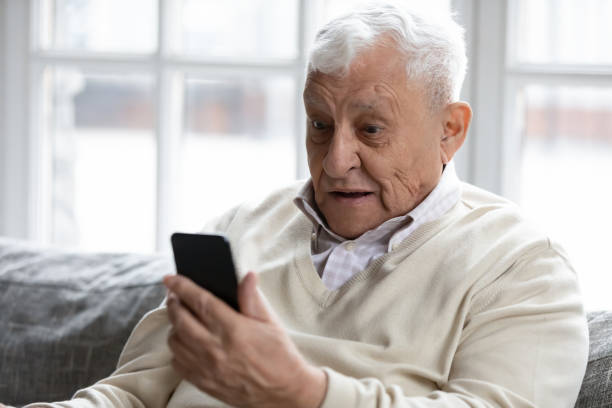 istock Close up surprised excited mature man looking at phone screen 1264699584