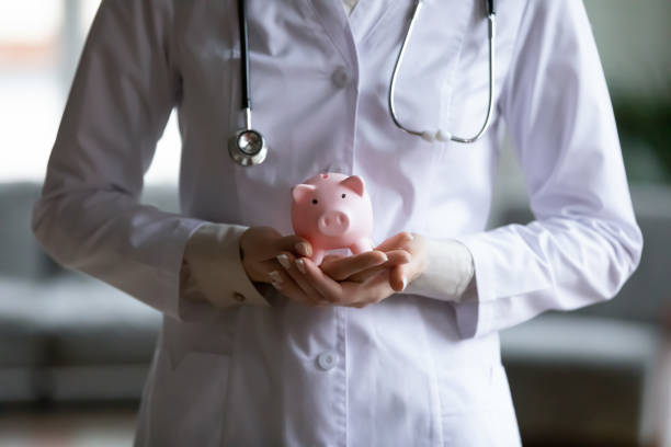 close up young female doctor holding pink piggy bank - currency stethoscope medicare usa imagens e fotografias de stock