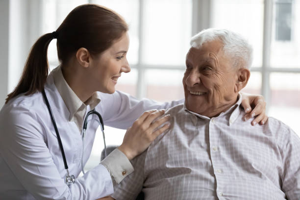 istock Female caregiver doctor supporting smiling older man, touching shoulders 1264699607