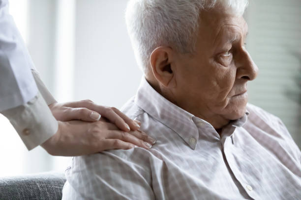 istock Close up caregiver supporting upset elderly man, touching patient shoulder 1264699610