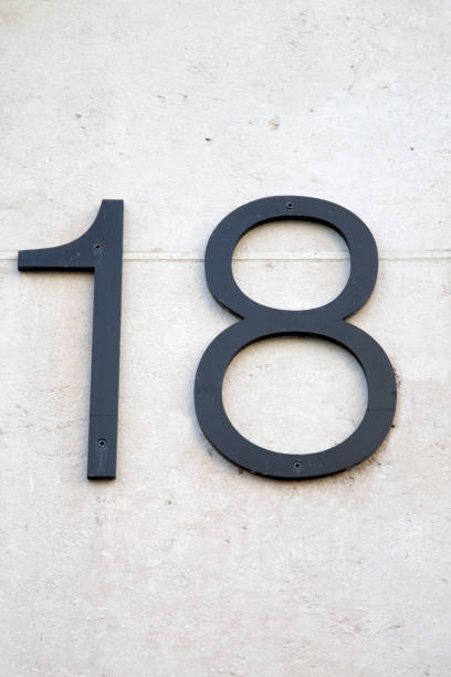 istock Number Eighteen Sign on Stone Wall 1264702595