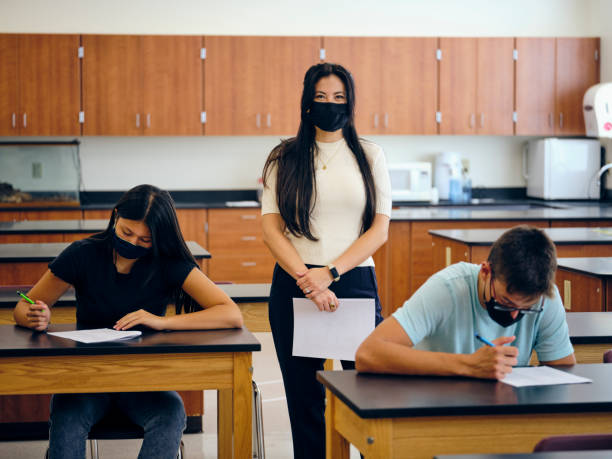 istock High School Teacher and Students In Classroom Wearing Protective Face Mask 1264703568