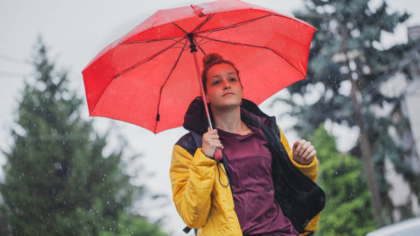 istock Beautiful woman on the street while raining 1264705678
