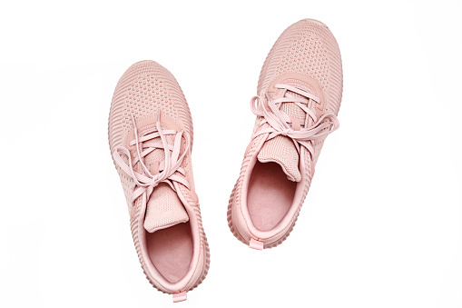 Pink female sneakers isolated on white background. Flat lay, top view. Sport casual shoes