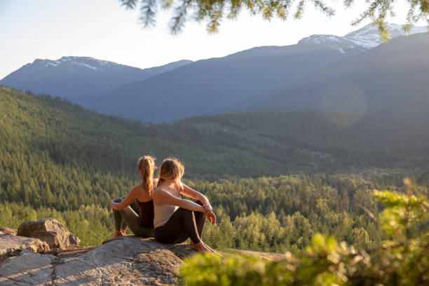 istock Young women relax on rock slabs, look off to view 1264706455