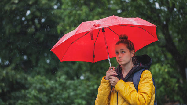 istock Beautiful woman on the street while raining 1264706460