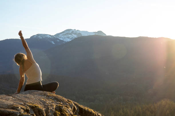 istock Young woman performs yoga moves on rock slabs 1264706654