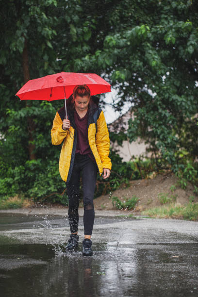 istock Beautiful woman on the street while raining 1264706782