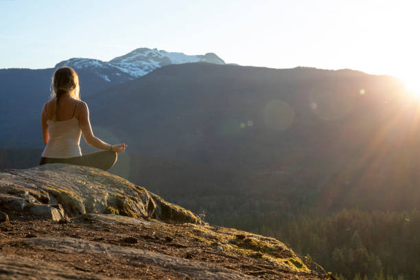 istock Young woman performs yoga moves on rock slabs 1264706789