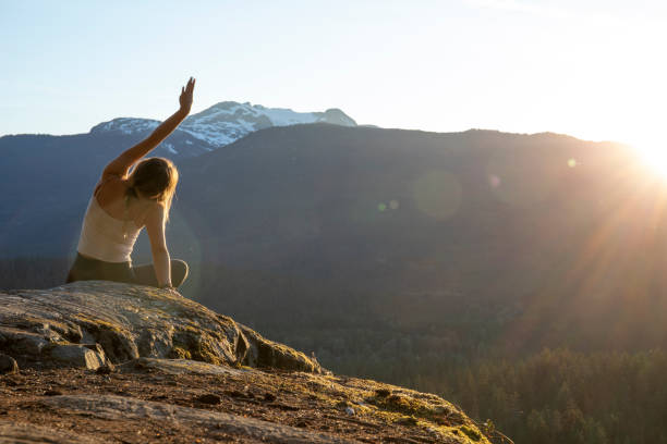 istock Young woman performs yoga moves on rock slabs 1264706828