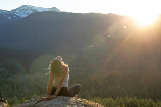 istock Young woman performs yoga moves on rock slabs 1264706878