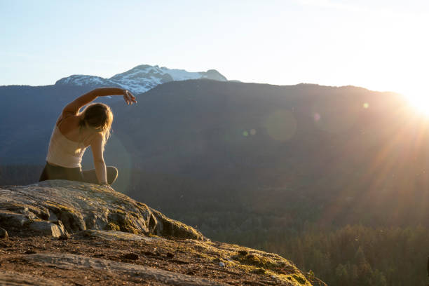 istock Young woman performs yoga moves on rock slabs 1264706880