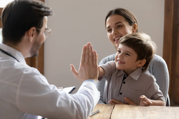 happy little boy kid giving high five to friendly doctor. - médico geral imagens e fotografias de stock