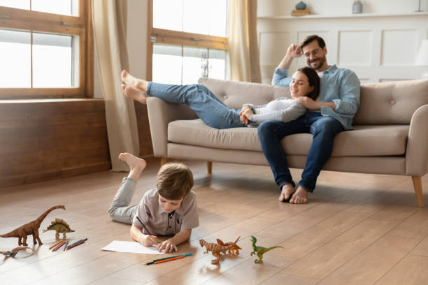 istock Parents relaxing on sofa, watching little kid son drawing pictures. 1264706912