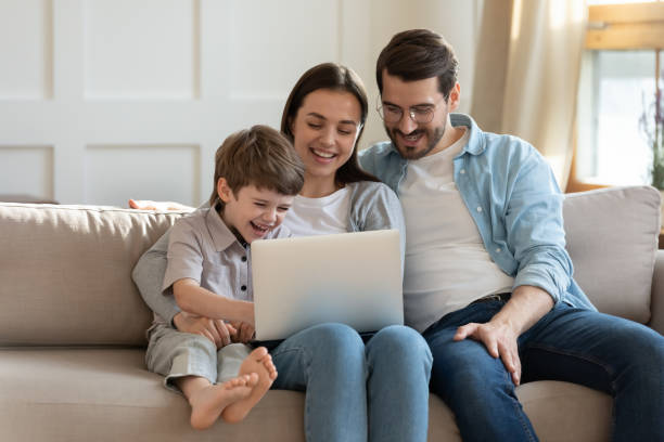 istock Happy young woman using computer with husband and small kid. 1264706914