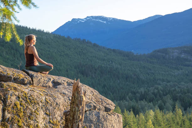 istock Young woman performs yoga moves on rock slabs 1264707033