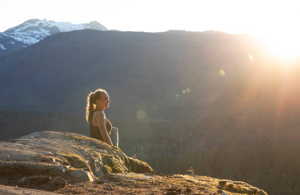 istock Young woman performs yoga moves on rock slabs 1264707729