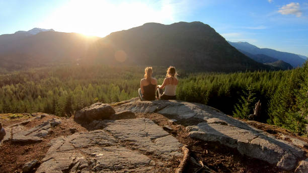 istock Young women relax on rock slabs, look off to view 1264707742