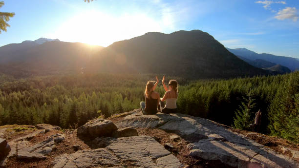 istock Young women relax on rock slabs, look off to view 1264707794