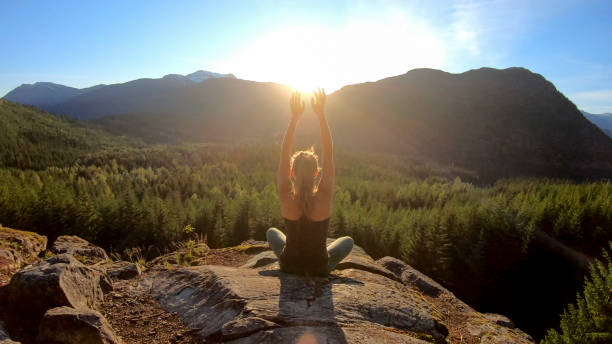 istock Young woman performs yoga moves on rock slabs 1264707824