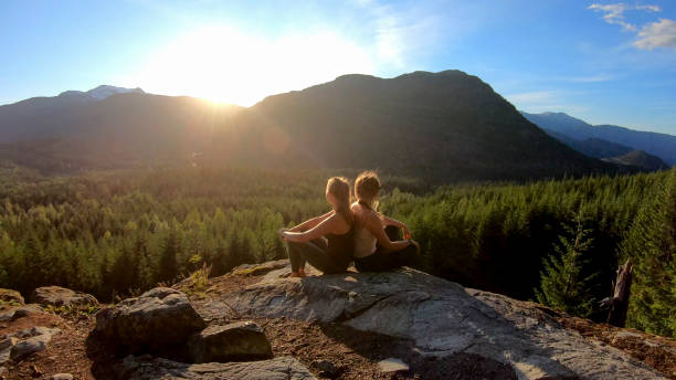 istock Young women relax on rock slabs, look off to view 1264707855