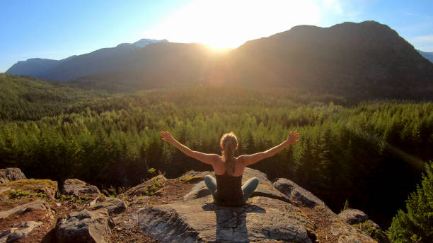 young woman performs yoga moves on rock slabs - growth tree spirituality tranquil scene imagens e fotografias de stock