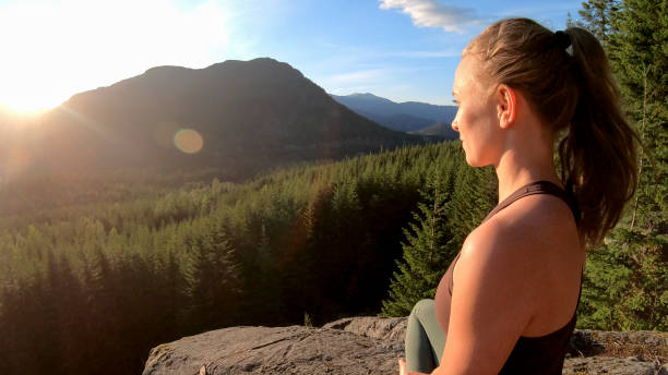 istock Young woman relaxes on rock slabs, looking off 1264707888