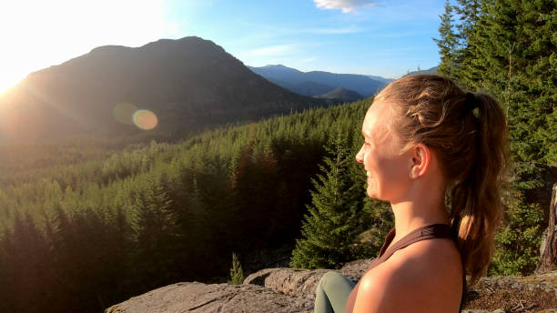istock Young woman relaxes on rock slabs, looking off 1264707949