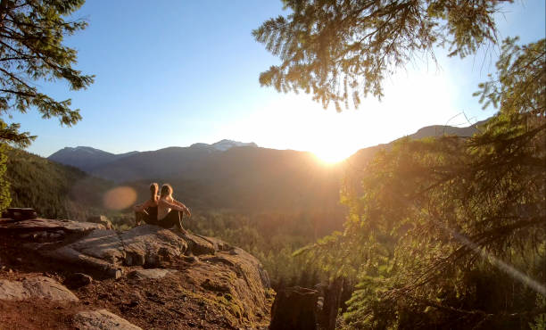 istock Young women relax on rock slabs, look off to view 1264708003