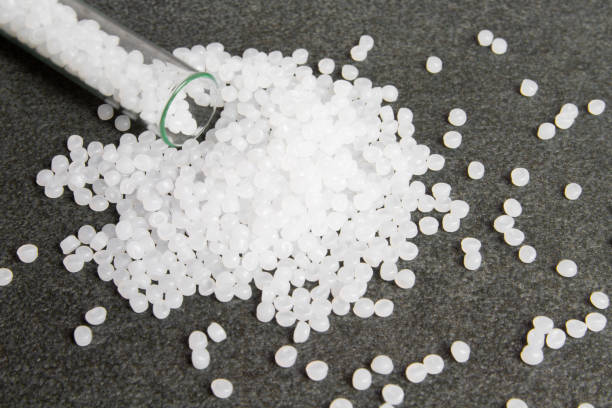 istock Plastic pallets. White Polyethylene granules on a stone background. Plastic Raw material .High Density Polyethylene. 1264709886