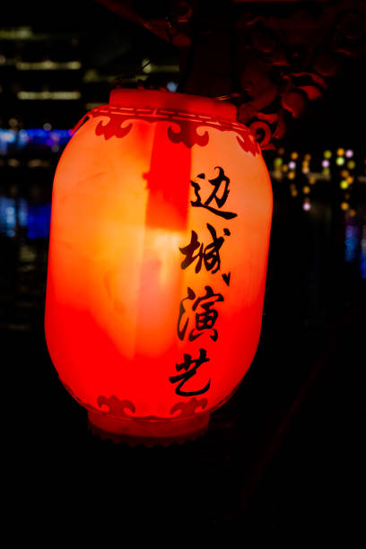 Feng Huang, China -  August 2019 : Red, yellow and orange lantern with Chinese writing characters hanging on the old historic wooden tourist boats in Feng huang Old Town
