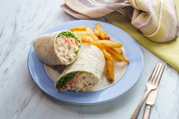 Tuna salad wrap sandwich with french fried potatoes