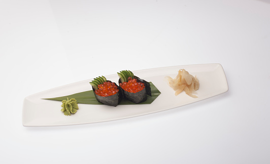 Salmon egg sushi served with white plant front of white background.