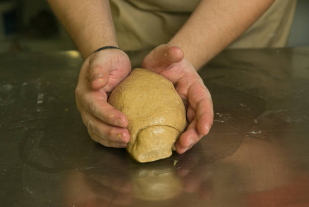 istock The process of making bread. The chef kneads the dough by hand.The dough is ready for baking. The chef prepares bread for baking. 1264716656