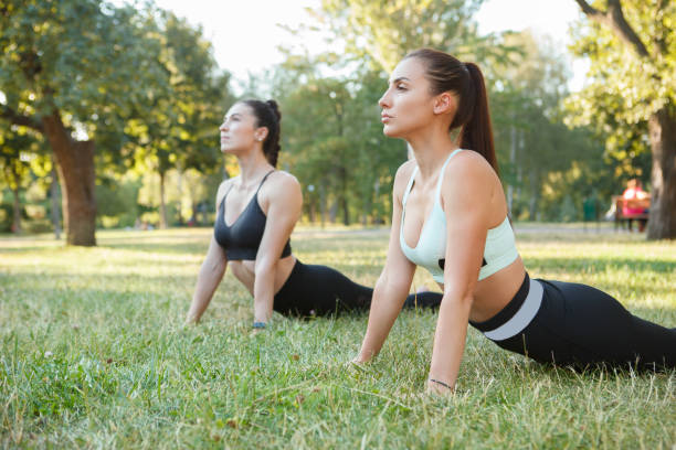 istock Women practicing yoga at the park 1264717802